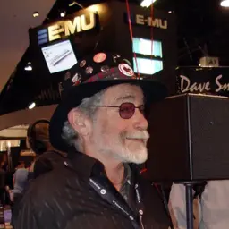 Don Buchla at a trade show in 2006, wearing a badge-covered hat